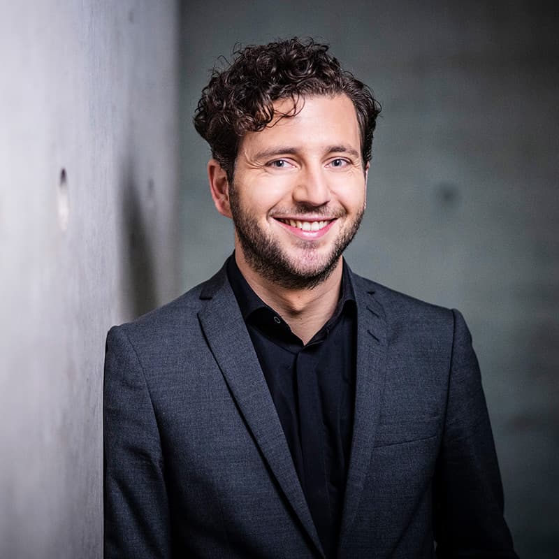 Felix Banaszak an Betonwand gelehnt